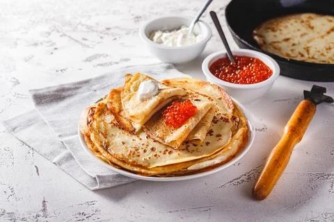 Stack of russian pancakes blini with red caviar, fresh sour cream Stock Photos