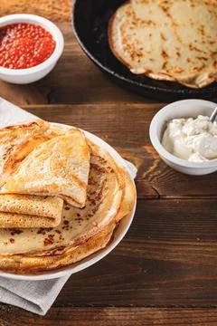 Stack of russian pancakes blini with red caviar, fresh sour cream Stock Photos