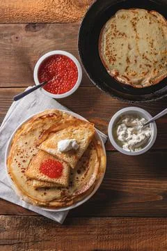 Stack of russian pancakes blini with red caviar, fresh sour cream Stock Photos