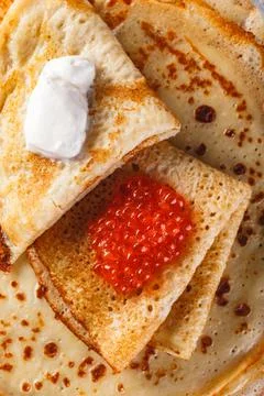 Stack of russian pancakes blini with red caviar, fresh sour cream Stock Photos