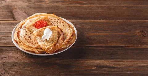 Stack of russian pancakes blini with red caviar, fresh sour cream Stock Photos