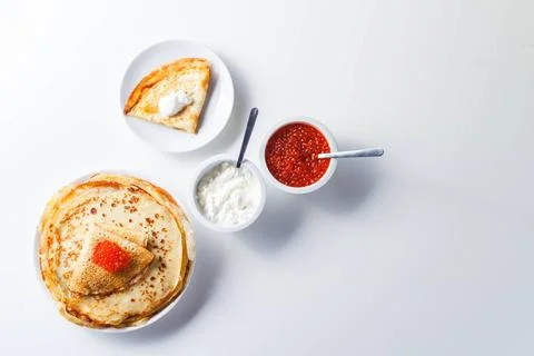 Stack of russian pancakes blini with red caviar, fresh sour cream Traditio... Stock Photos