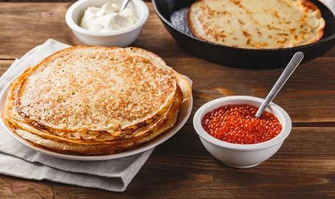 Stack of russian pancakes blini with red caviar, fresh sour cream Stock Photos