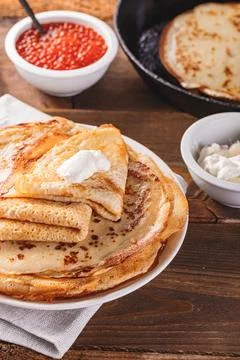 Stack of russian pancakes blini with red caviar, fresh sour cream Stock Photos