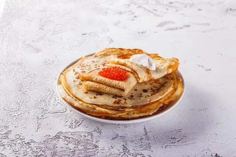 Stack of russian pancakes blini with red caviar, fresh sour cream Stock-Fotos