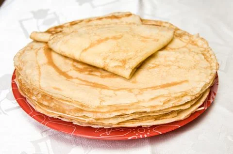 A stack of russian pancakes on a red plate Stock Photos
