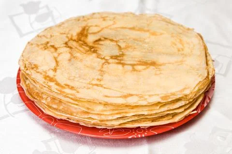 A stack of russian pancakes on a red plate Foto stock