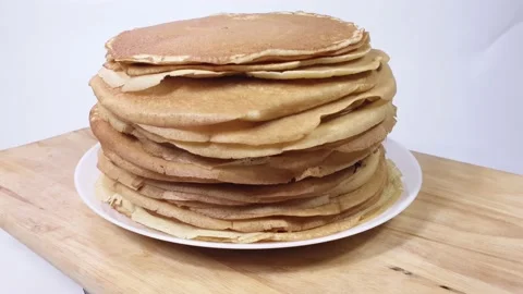 A stack of Russian pancakes on a white background on a wooden board, pancakes on Vídeos de archivo 149315417