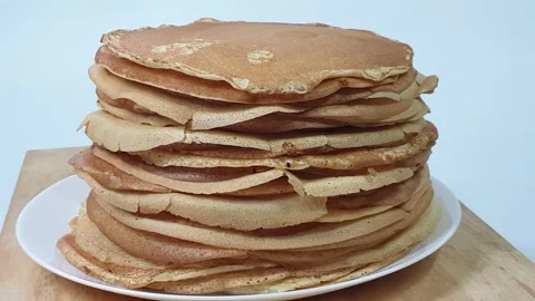 A stack of Russian pancakes on a white background on a wooden board, pancakes on Vídeo Stock 150449161