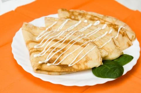 A stack of russian pancakes on a white plate Stock Photos