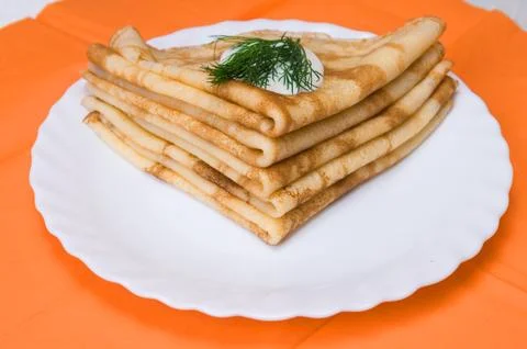 A stack of russian pancakes on a white plate Stock Photos