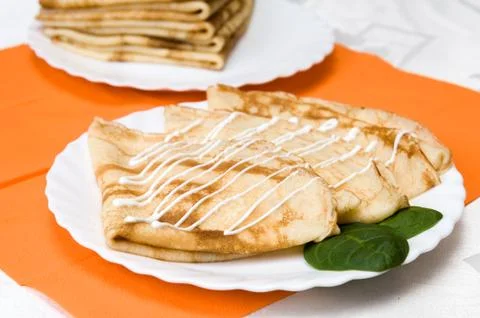 A stack of russian pancakes on a white plate Stock Photos