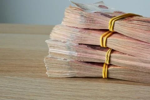 A stack of Russian ruble banknotes on the background of a wooden table. Stock Photos