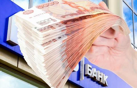 Stack of russian rubles in the hand against the signboard. Text in russian:.. Stock Photos