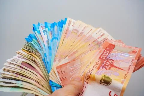 Stack of Russian rubles held in hand with various denominations visible, sh.. Stock Photos