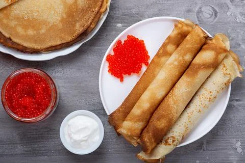 Stack of russian thin pancakes blini with red caviar and fresh sour cream Stock Photos