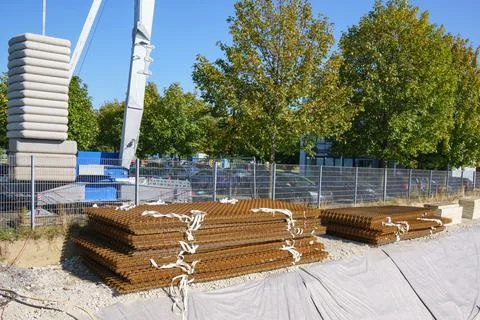 A stack of rusty brown steel mesh mats are lying on a building site.  Counter Stock Photos