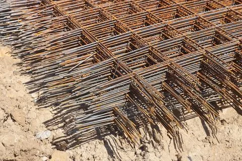 Stack of rusty wire mesh at a construction site. Metal building grate. Stock Photos