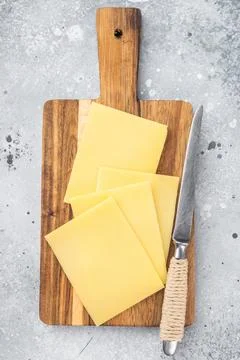 Stack of semi hard yellow cheese slices on rustic wooden cutting board, cop.. 스톡 사진