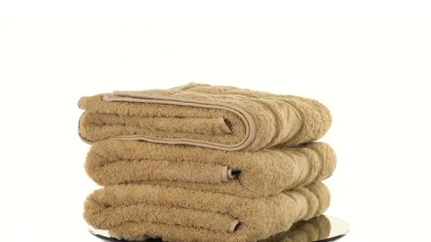 A stack of several bath towels, terry for the spa, rotates on a white backgro Stock Footage 139614991