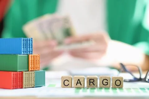 Stack of several containers, cubes with the word cargo and glasses on financial 스톡 사진