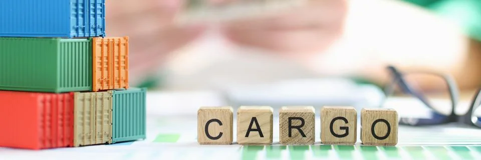 Stack of several containers, cubes with the word cargo and glasses on financial 스톡 사진