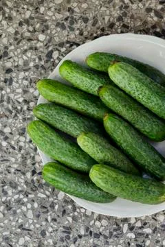 A stack of several fresh green cucumber gherkins in a plate Stock Photos