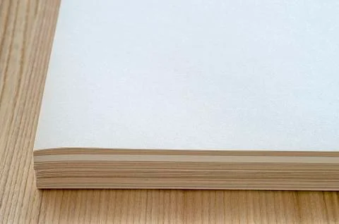 A stack of sheets of clean paper lies on the surface of the table with a natu Stock Photos
