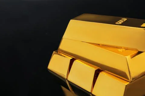 Stack of shiny gold bars on black background, closeup. Space for text Foto stock