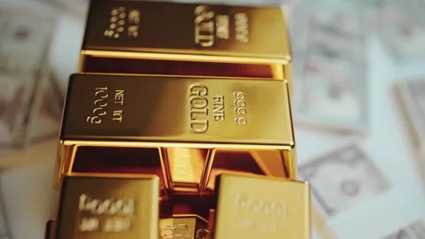 Stack of shiny gold bars piled on US dollar bills symbolizing wealth and fi.. Stock Footage 337447931