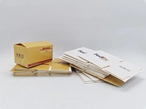 Stack Of Shipping Envelopes And Boxes From DHL And FedEx For Express Delivery Stock Photos