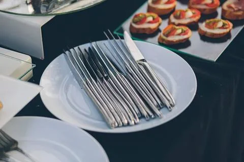 Stack of silver forks on a white plate at a buffet 스톡 사진