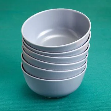 A stack of six gray bowls on green background. Fotos de archivo