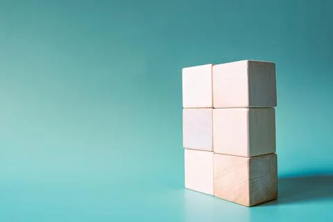 A stack of six wooden cubes on a light blue background. Mockup, copy space. C Stock Photos