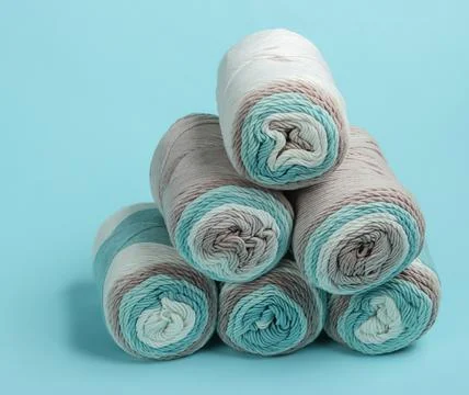 Stack of skeins of woolen threads close-up on blue background Stock Photos