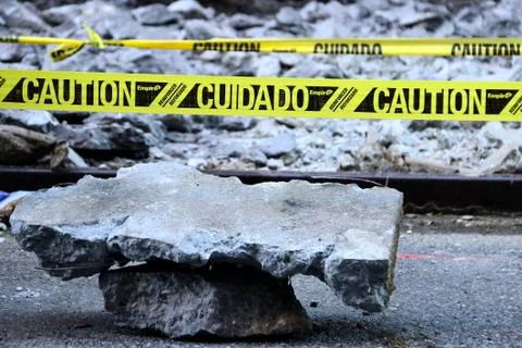 A stack of slabs of pavement with caution sign Stock Photos