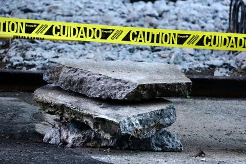 A stack of slabs of pavement with caution sign Foto stock