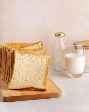 Stack of slice bread isolated on bright background with fresh milk. Close up. Stock Photos