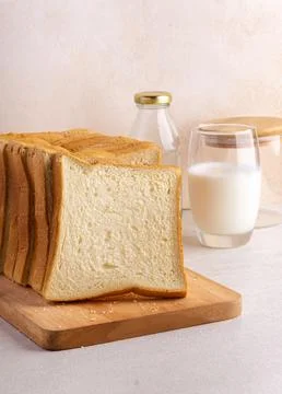 Stack of slice bread isolated on bright background with fresh milk. Close up. Stock Photos