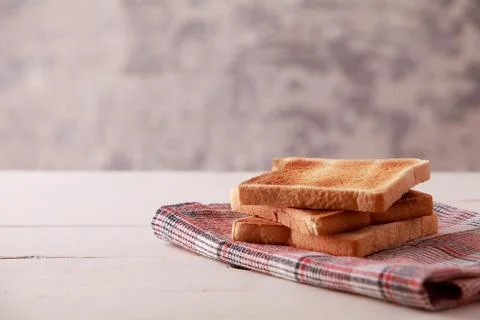A stack of sliced bread toasts on white wooden background Stock Photos