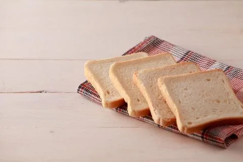 A stack of sliced bread toasts on white wooden background Stock Photos