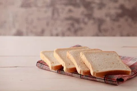 A stack of sliced bread toasts on white wooden background Stock Photos
