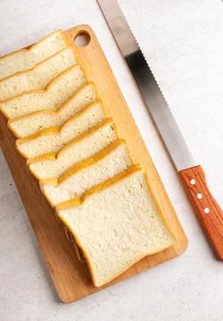 Stack of sliced white bread and cutting knife. White background texture. Fl.. Stock Photos