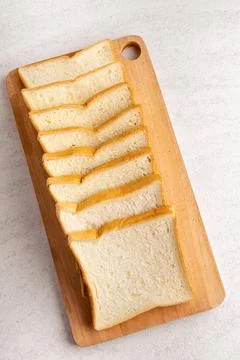 Stack of sliced white bread on cutting board. White background texture. Fla.. Stock Photos