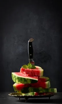 A stack of slices of ripe red watermelon in a metal plate, stuck in a large k Stock Photos