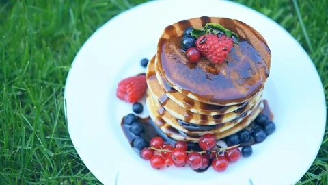 Stack of small pancakes in syrup on green background Stock Footage 73076457