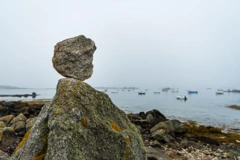 Stack of small rocks near the sea on a foggy day in summer Stock Photos