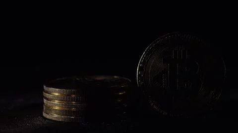 A stack of small shiny silver and gold coins next to a single large gold bi.. Stock Footage 334720042