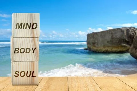 Stack of small wooden cubes with the text of mind, body, and soul on the tabl 스톡 사진