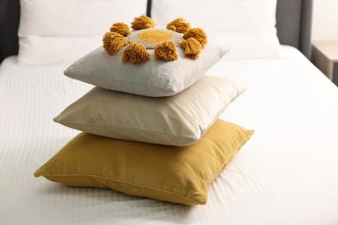 Stack of soft pillows and bedsheet on bed at home Stockfoto's